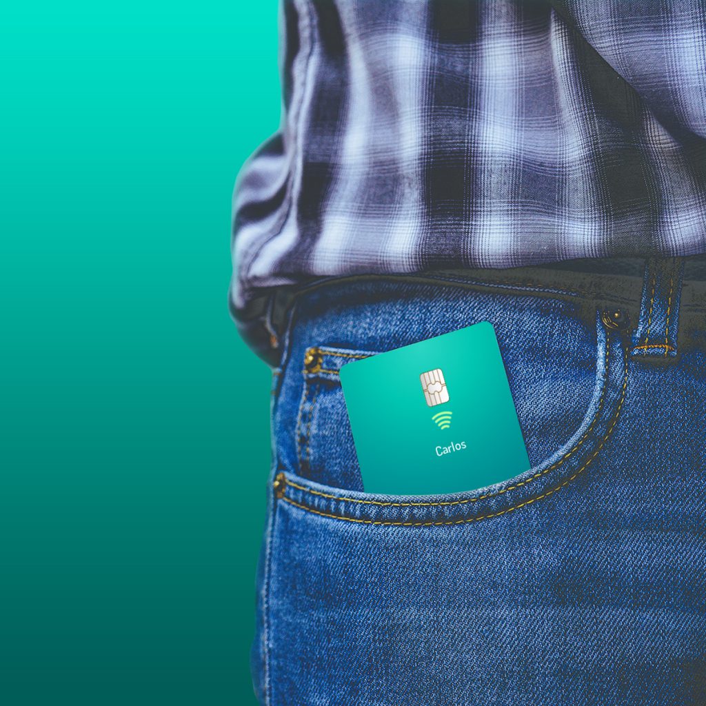 Foto a detalle de una tarjeta Stori dentro del bolsillo del pantalón de una persona con fondo en tonos azules verdosos.